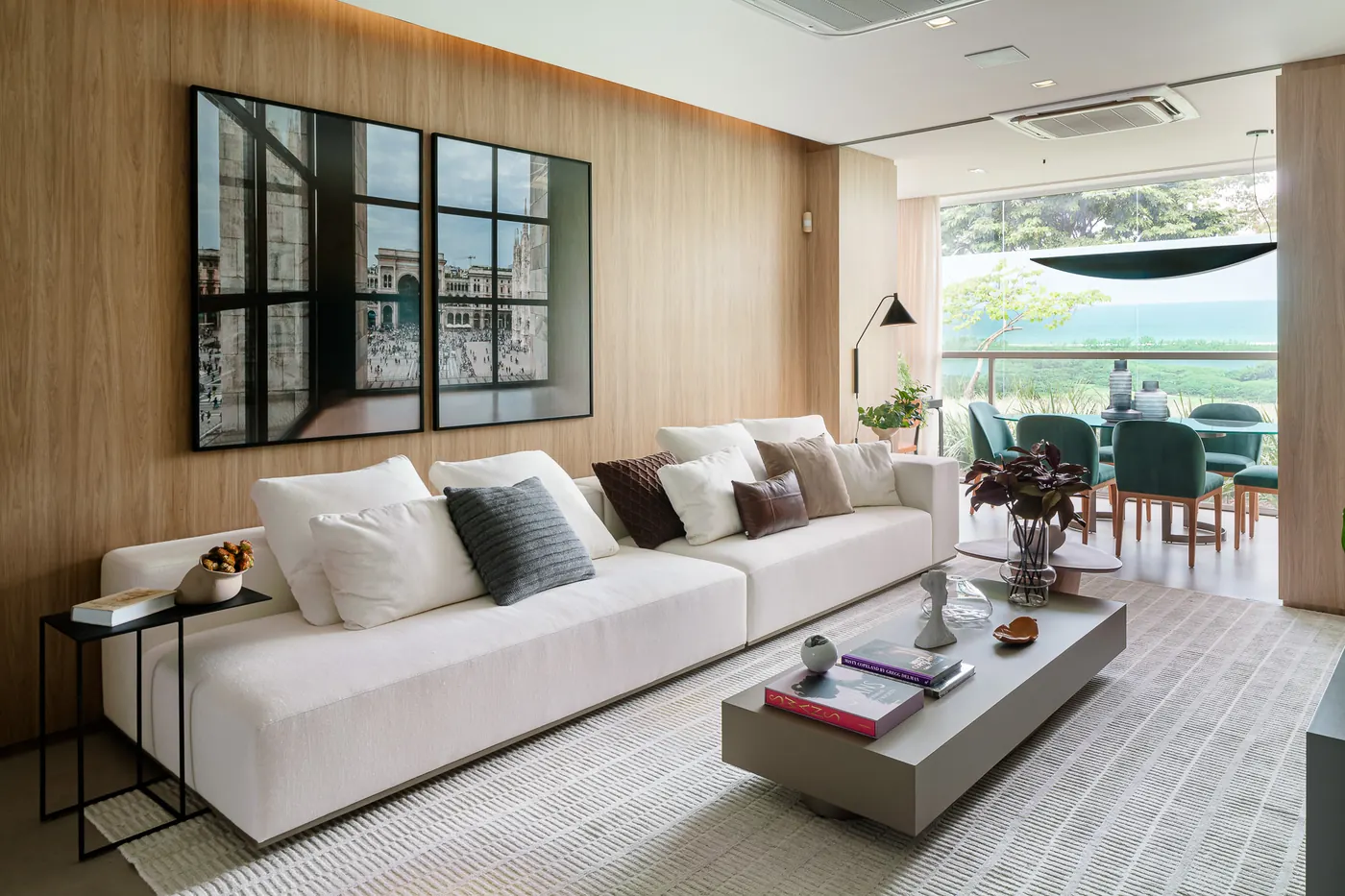 Sala do decorado de 132 m², com painel de madeira e sofá claro