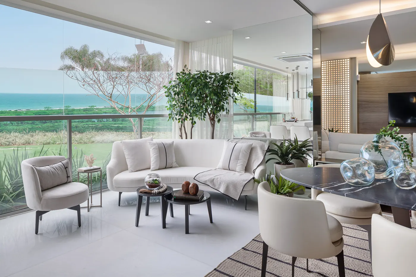 Varanda do decorado de 181 m², com sofás claros e vista para o verde
