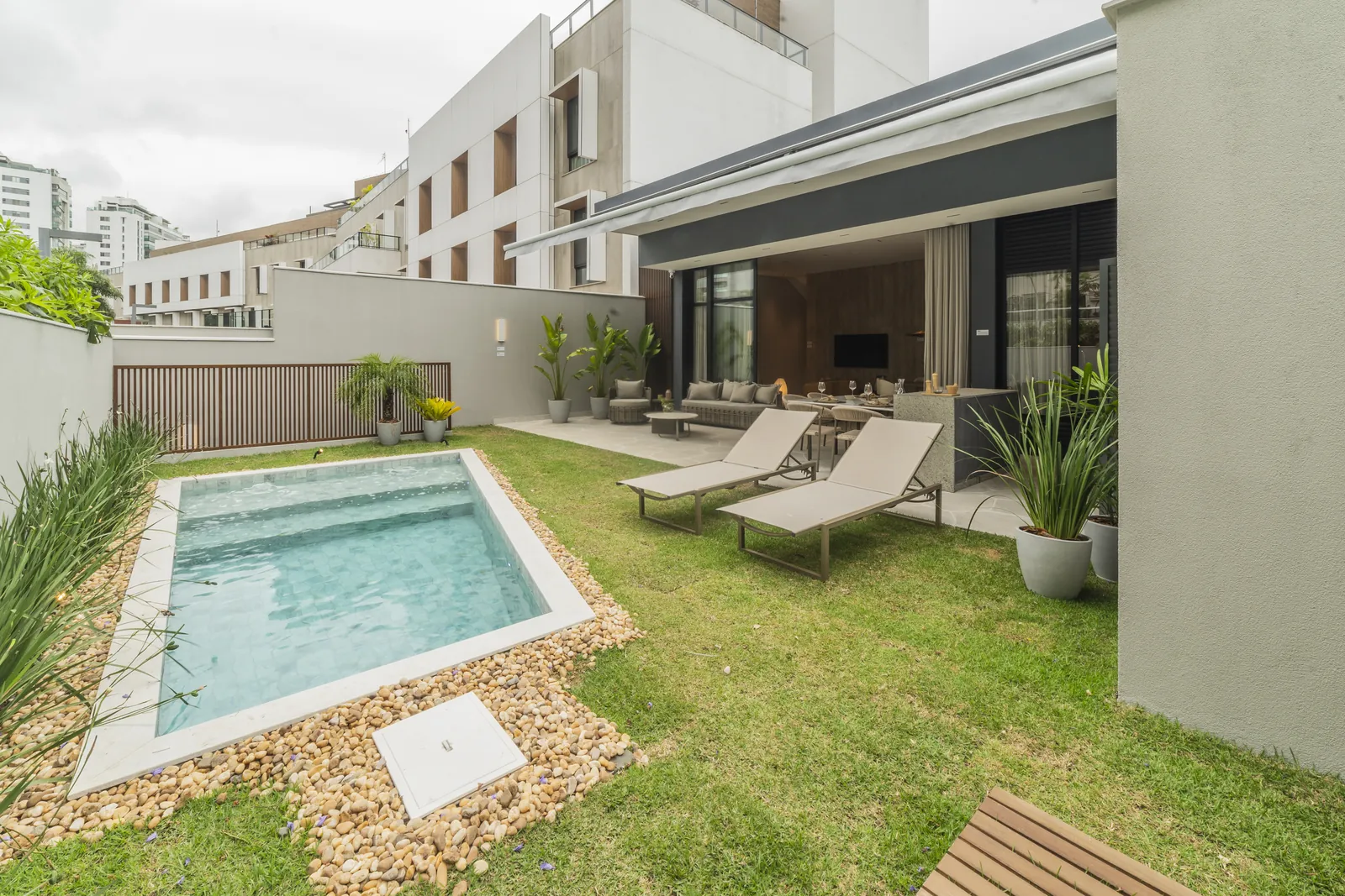 Quintal do decorado com piscina, gramado e espreguiçadeiras