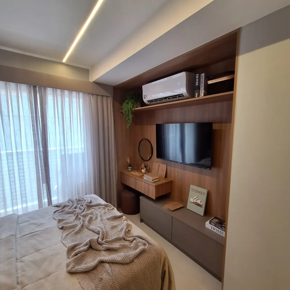 Suíte da cobertura decorada, com cama de casal e painel de madeira