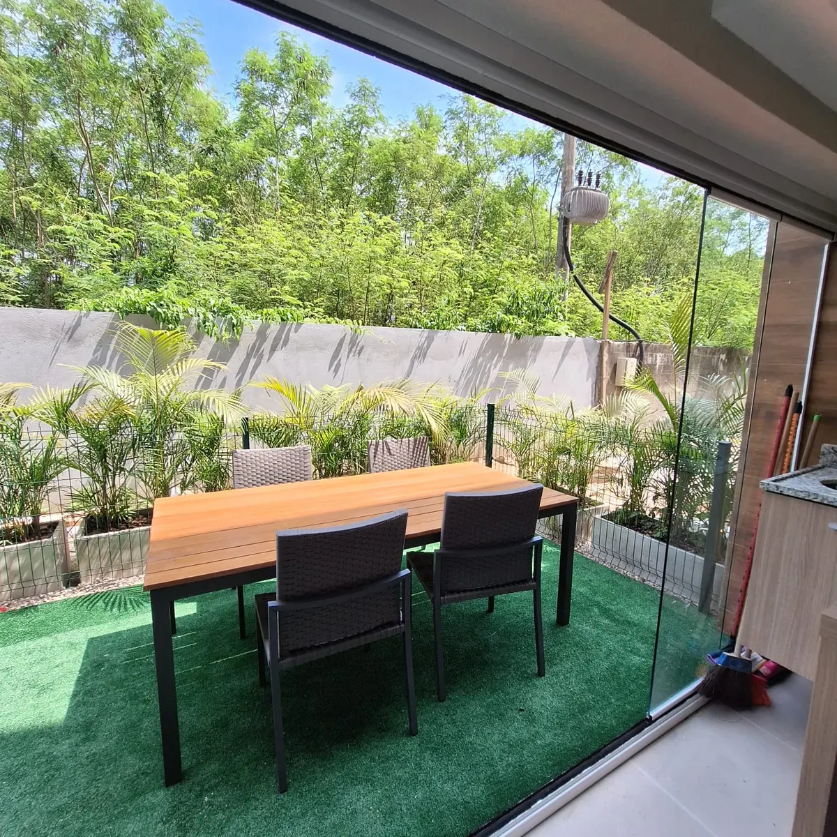 Jardim privativo do garden decorado, com mesa de jantar e vidro de piso a teto