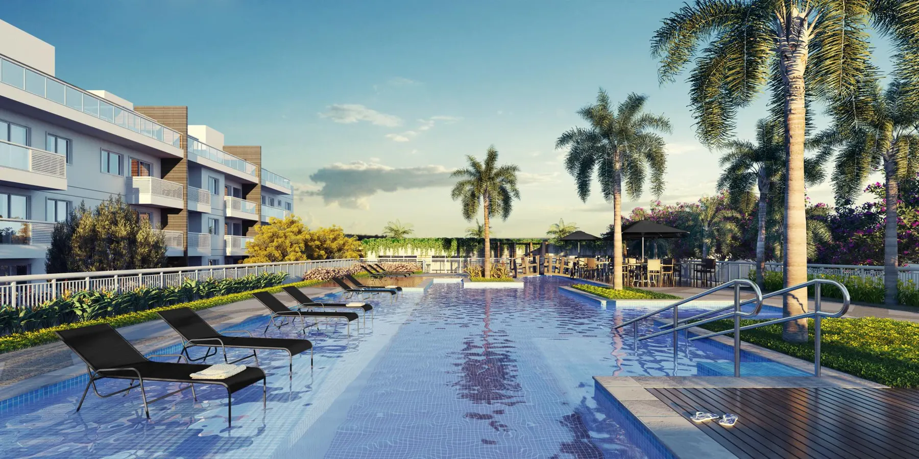Piscina com deck molhado, espreguiçadeiras e coqueiros