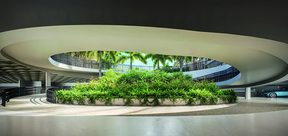 Rampa circular de chegada no subsolo, com um jardim no centro e luz natural de cima