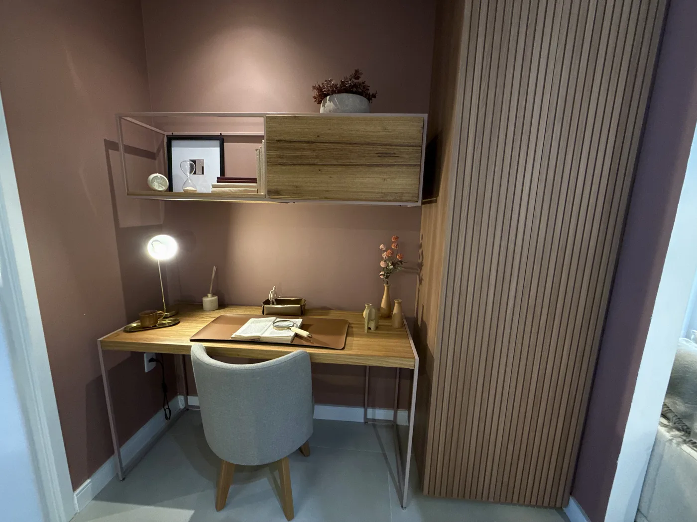 Foto real do quarto montado como escritório no apartamento decorado
